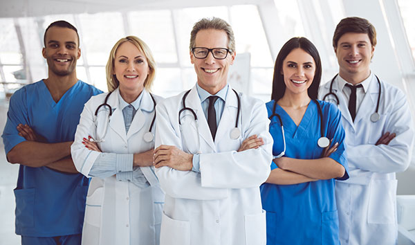 Clinic staff in scrubs and coats