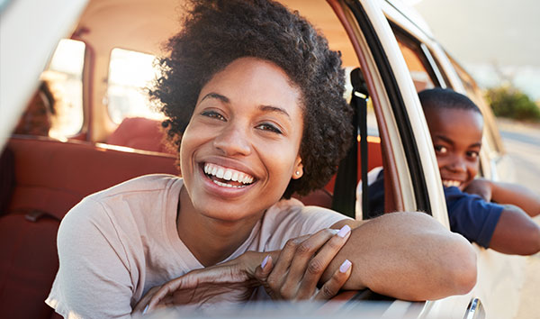 Woman look out from car with child in back seat